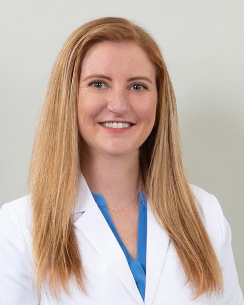 Jessica Logel, MSN, PMHNP-BC, FNP, smiling in a white coat